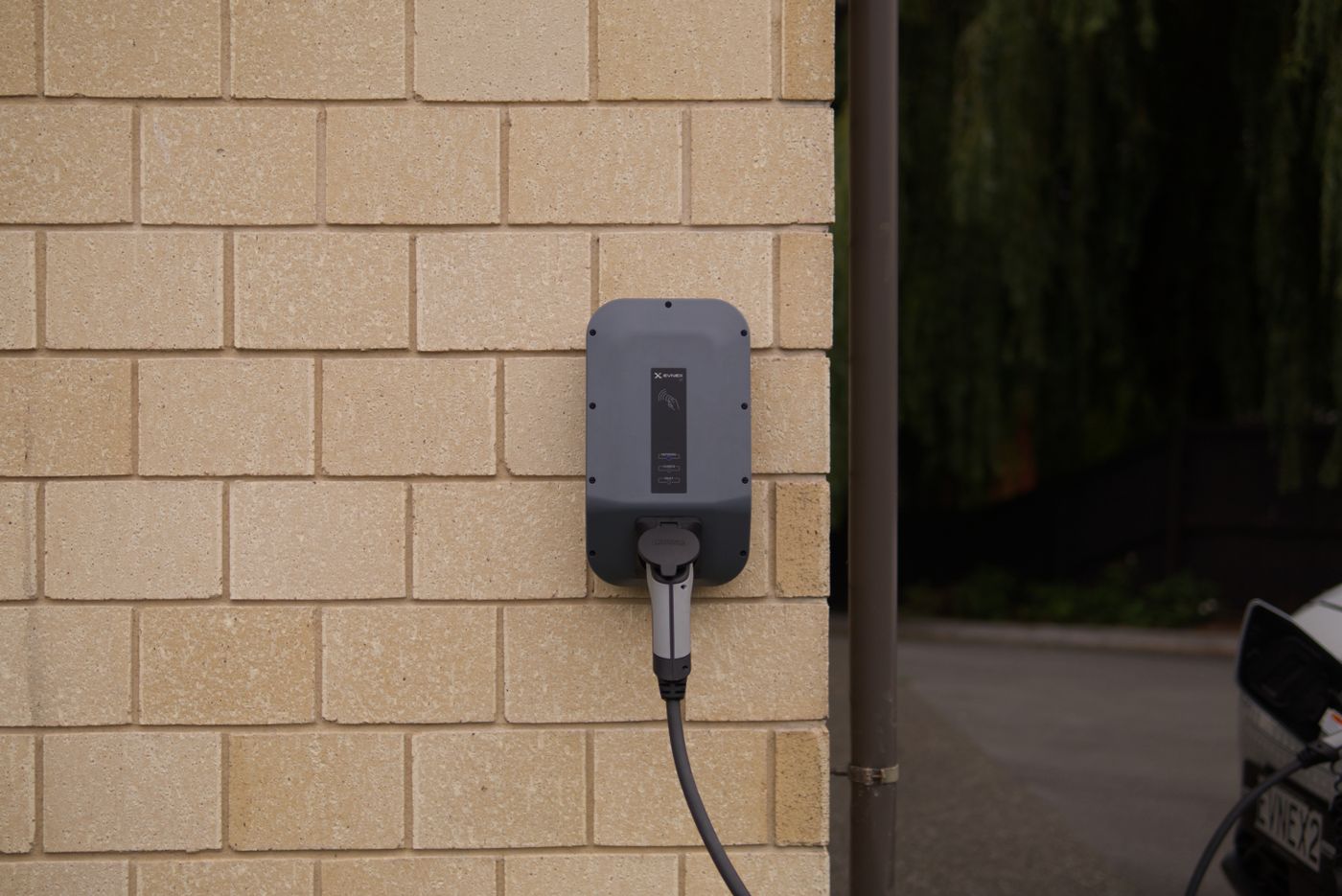 Borne de recharge murale sur une façade en brique